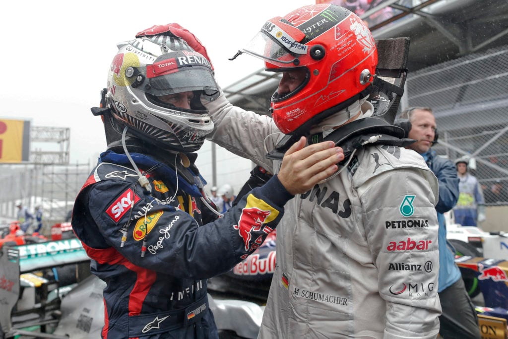 Michael Schumacher of Mercedes greets Sebastian Vettel of Red Bull at the 2012 Brazilian Grand Prix