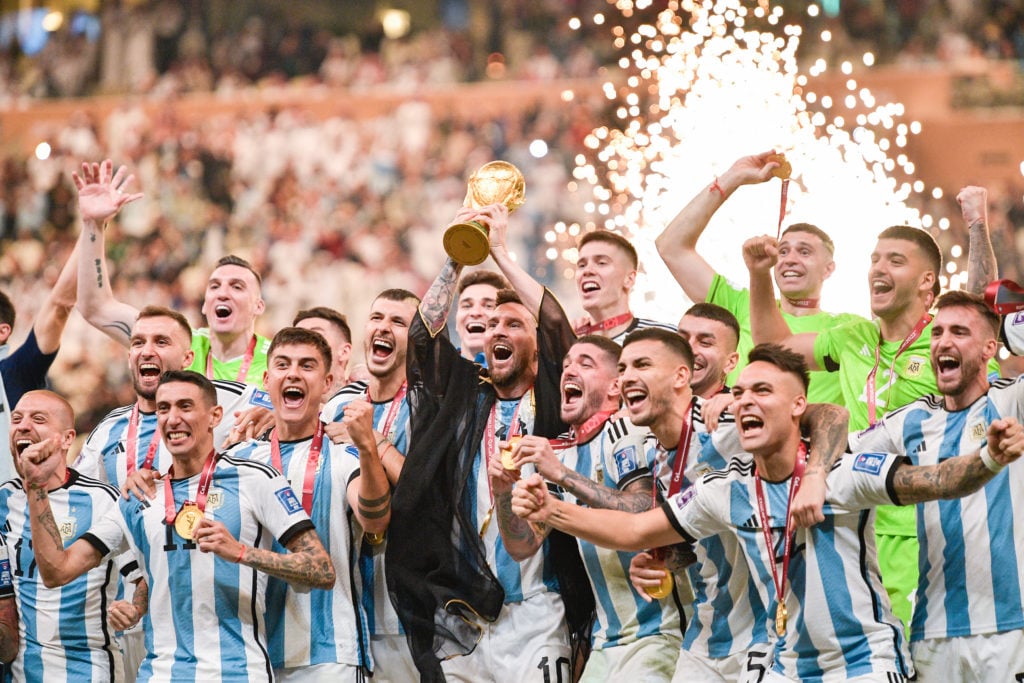 Argentina celebrate the world cup as Lionel Messi hoists the trophy above his head.