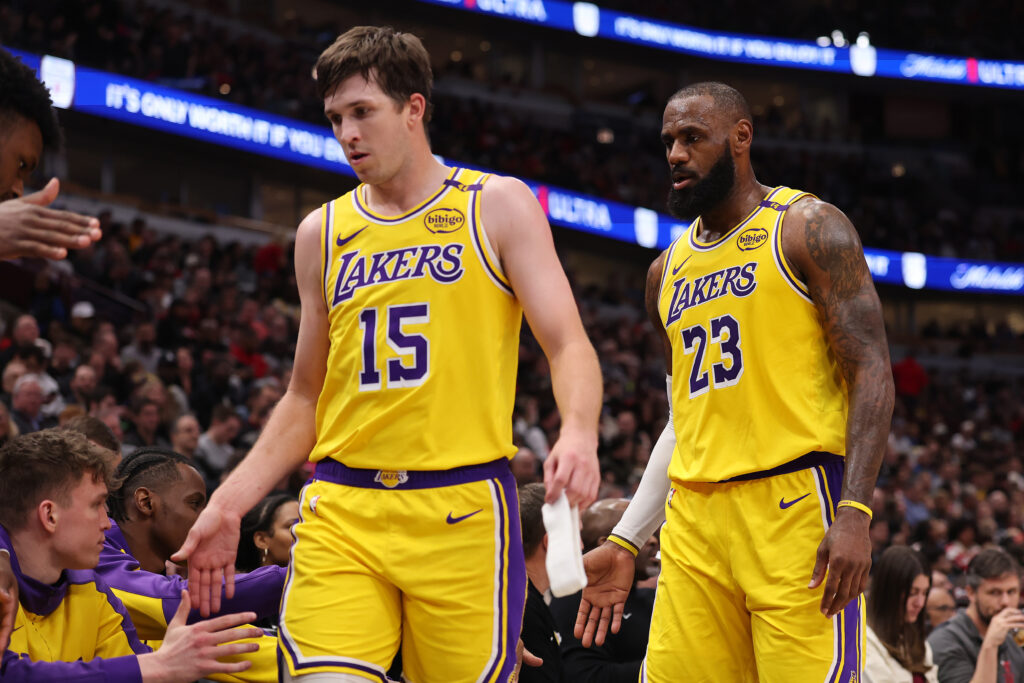 Austin Reaves #15 and LeBron James #23 of the Los Angeles Lakers high five teammates against the Chicago Bulls during the second half at the United Center on March 27, 2025 in Chicago, Illinois.