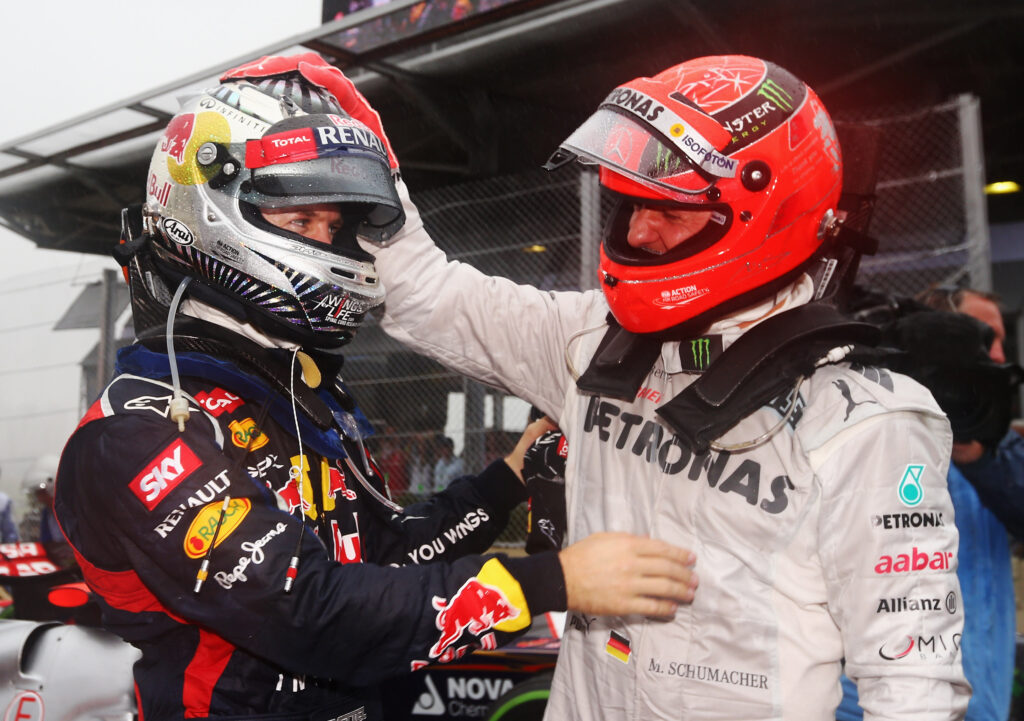 Michael Schumacher and Sebastian Vettel embrace after the 2012 Brazilian Grand Prix