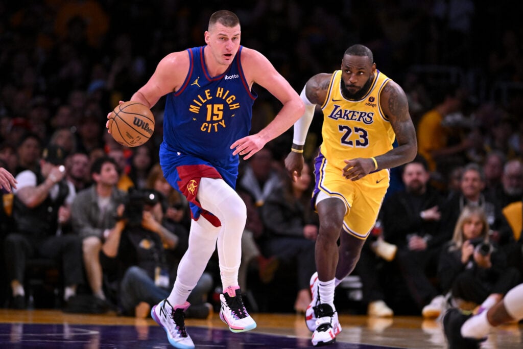 Nuggets Nikola Jokic, #15, drives downcourt followed by Lakers LeBron James.