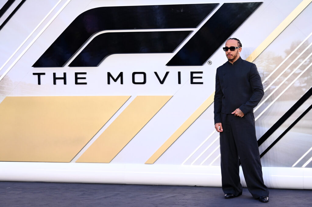 Lewis Hamilton in front of the "F1: The Movie" billboard