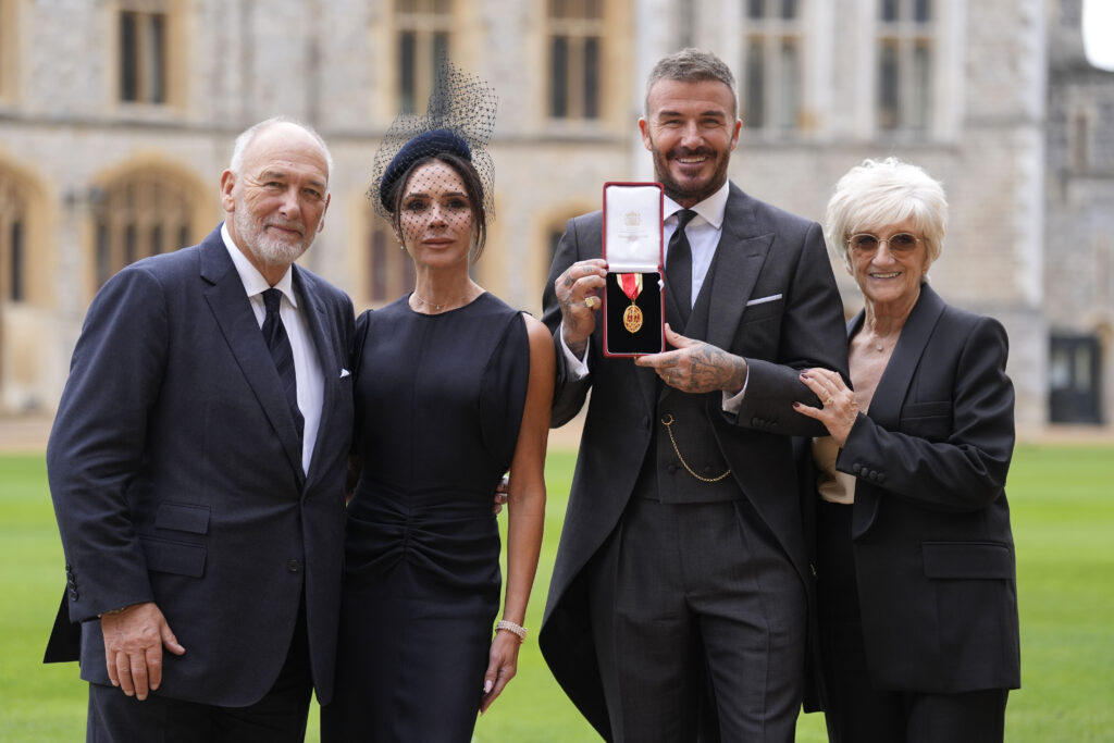 Sir David Beckham poses with his wife Lady Victoria and parents Ted and Sandra Beckham after receiving knighthood