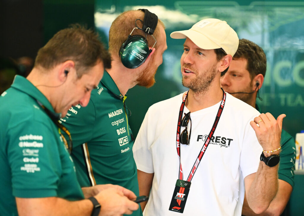 Sebastian Vettel chats to Aston Martin team members at the 2025 Brazilian Grand Prix