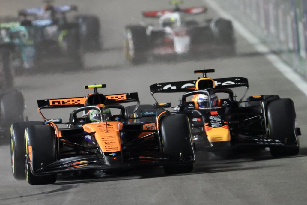 Max Verstappen and Lando Norris fighting for position at the first corner of the 2025 Las Vegas Grand Prix.