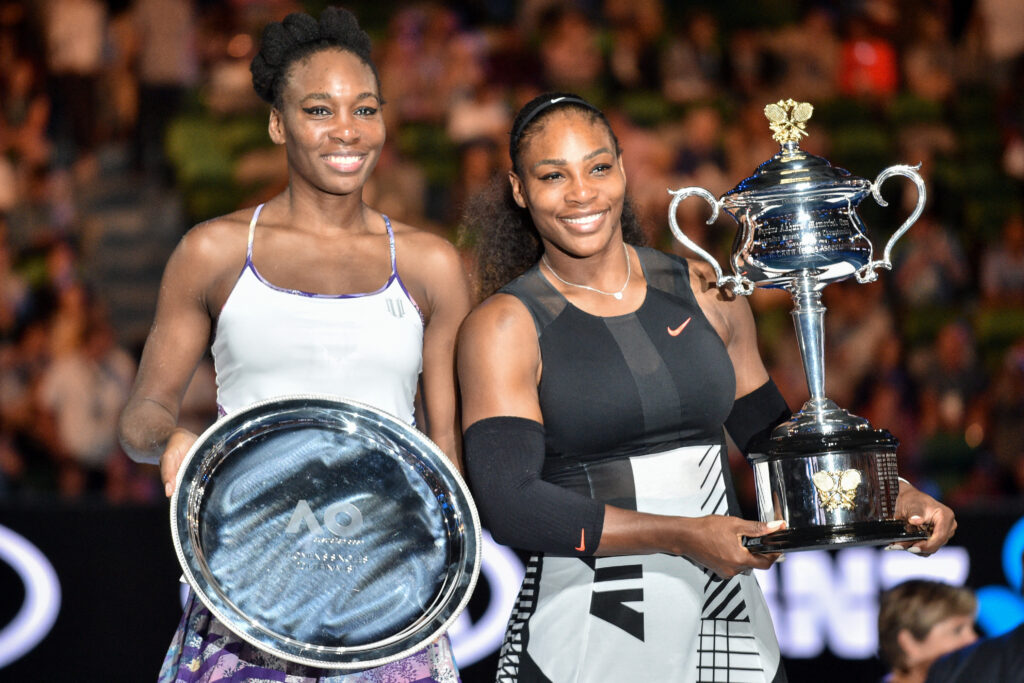 Serena Williams of the US (R) celebrates with the championship trophy during the awards ceremony after her victory against Venus Williams of the US in the women's singles final on day 13 of the Australian Open tennis tournament in Melbourne on January 28, 2017.