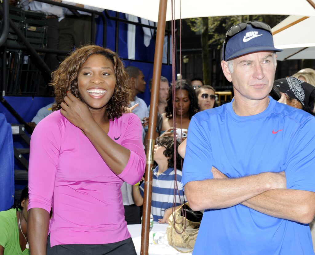 Serena Williams looks on with John McEnroe before their match at the DIRECTV ESPN US Open Experience promoting DIRECTV's mosaic coverage of the US Open August 26, 2009 at Bryant Park in New York City.