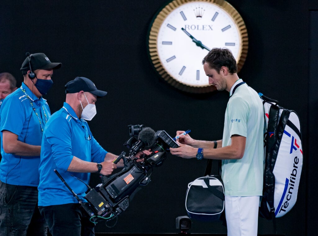 Daniil Medvedev signs the broadcast camera lens affter beating Nick Kyrgios in the second round of the 2022 Australian Open.
