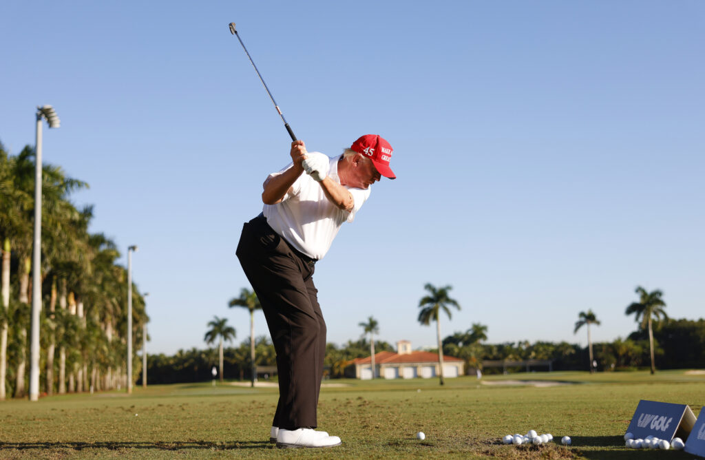 Former U.S. President Donald Trump plays a shot on the driving range during a pro-am prior to the LIV Golf Invitational