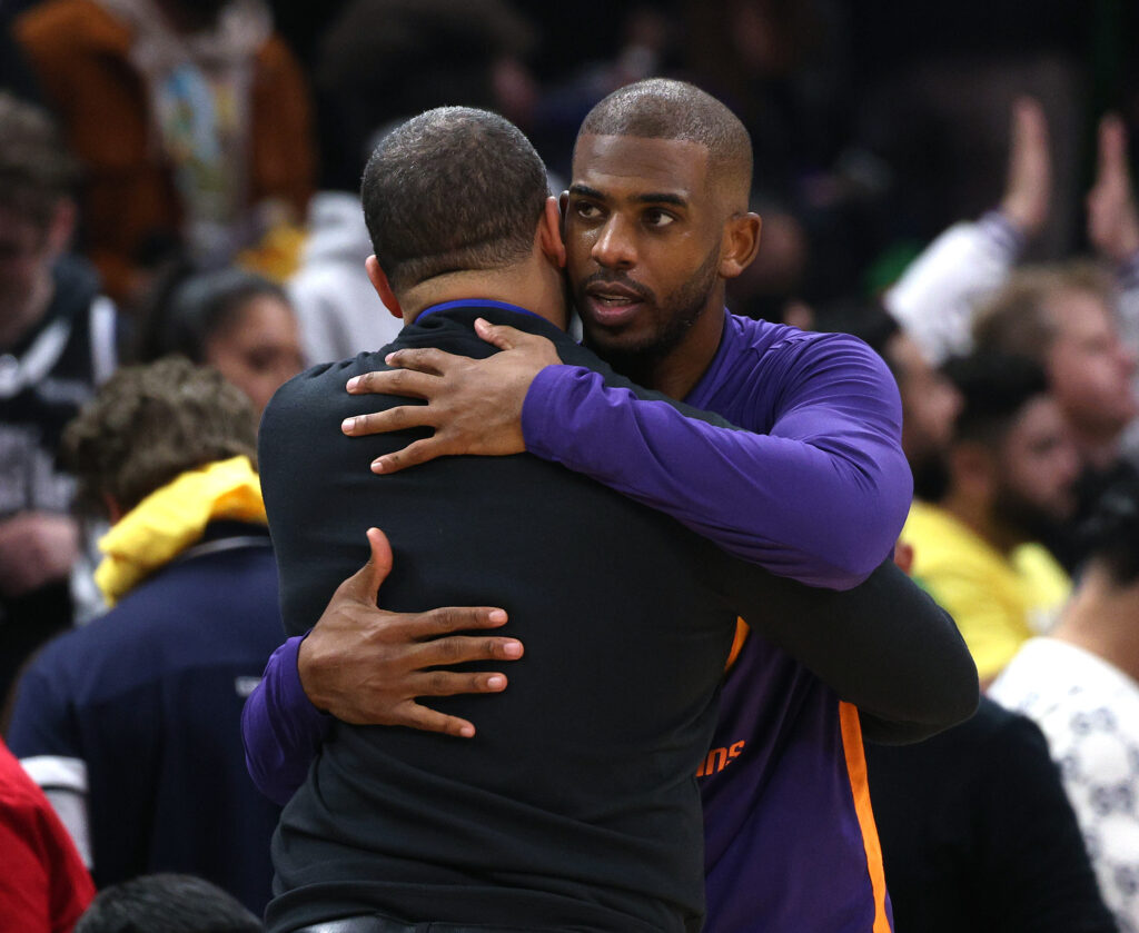 Chris Paul #3 of the Phoenix Suns hugs head coach Tyronn Lue of the LA Clippers during a 111-95 Suns win at Crypto.com Arena.
