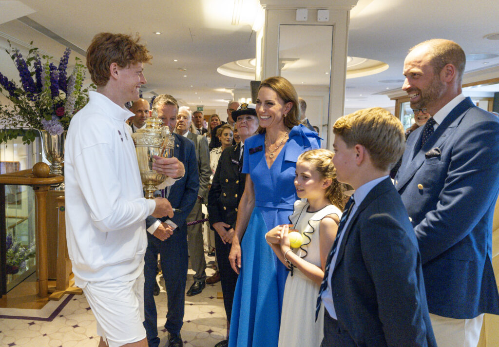 Jannik Sinner of Italy holds the Gentlemen's Singles Trophy as he meets with Catherine, Princess of Wales, Patron of the All England Lawn Tennis Club, Prince William, Prince of Wales, Princess Charlotte of Wales and Prince George of Wales in the Clubhouse after winning the Gentlemen's Singles Final