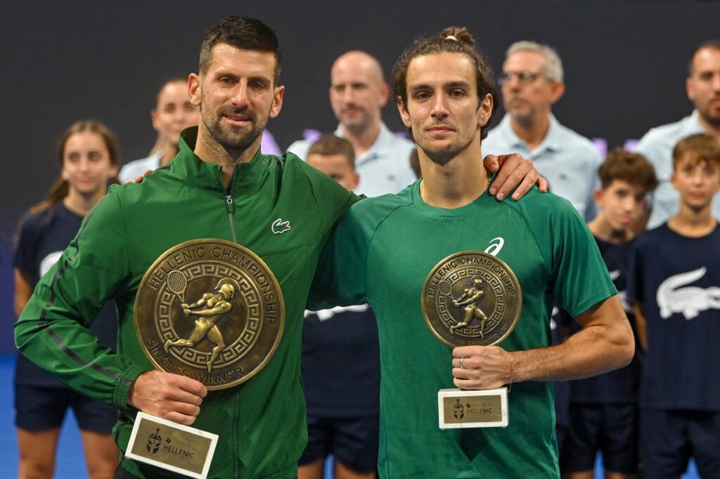 Novak Djokovic and Lorenzo Musetti pose with their trophies after the 2025 Hellenic Championship final