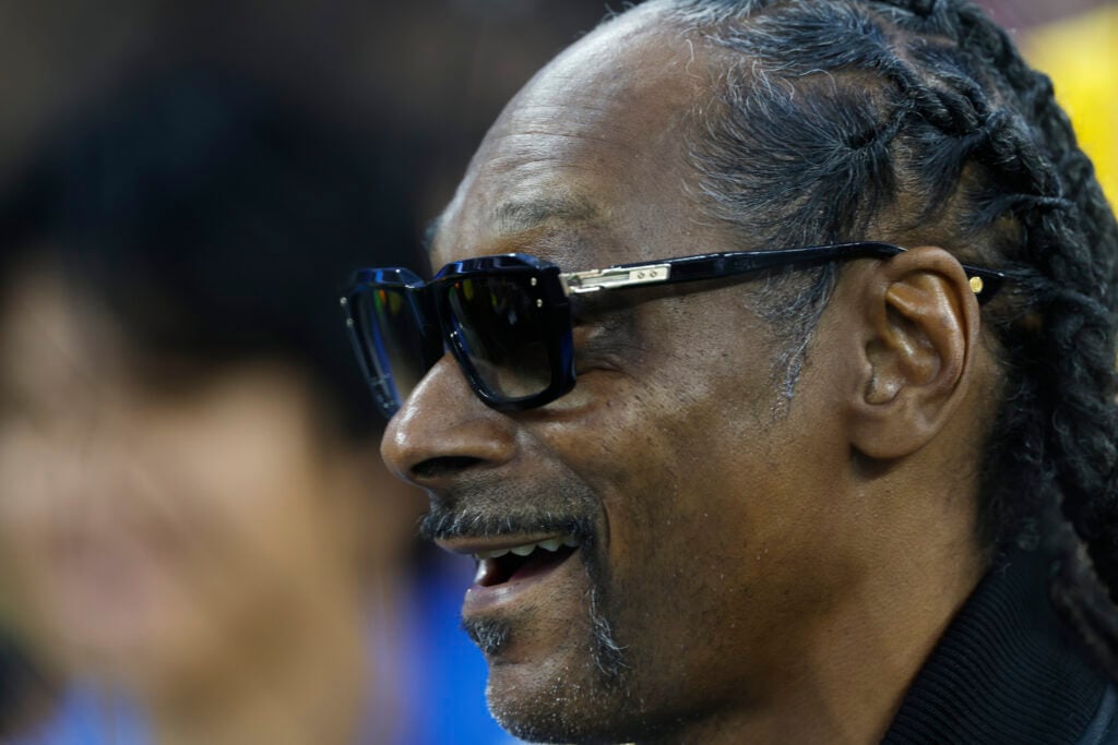 Snoop Dogg looks on.