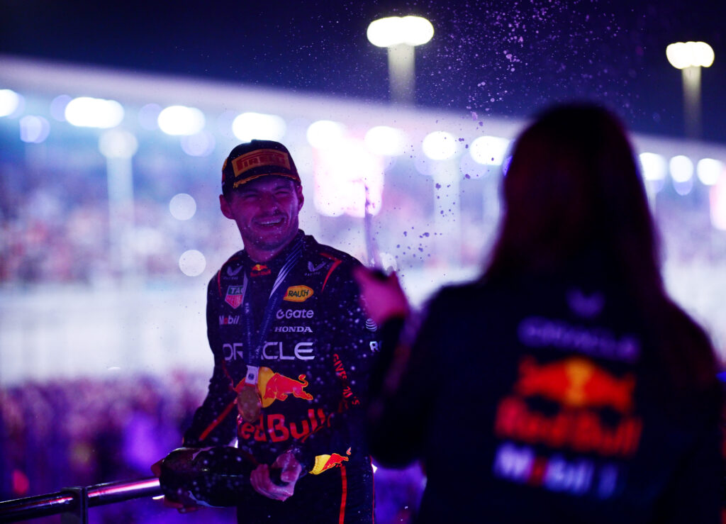 Max Verstappen spraying a Red Bull colleague with champagne on the podium of the 2025 Qatar Grand Prix.
