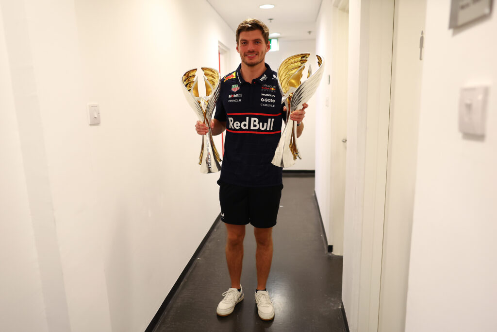 Max Verstappen holds the winning drivers' and constructors' trophies after the 2025 Abu Dhabi Grand Prix