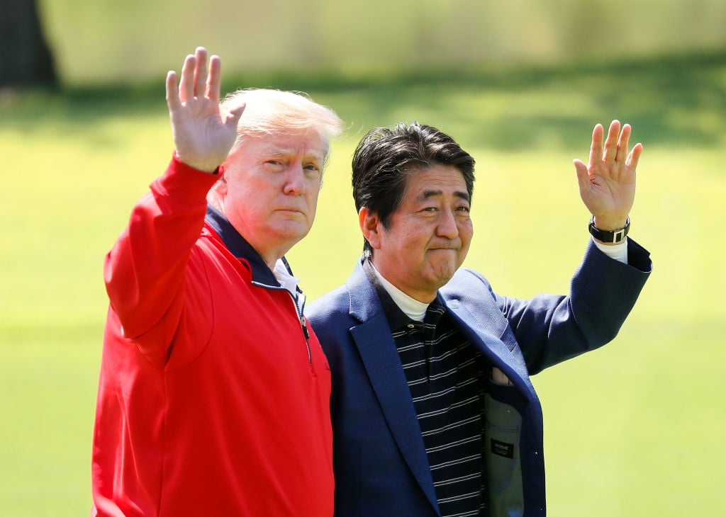 President Donald Trump and Japanese Prime Minister Shinzo Abe wave on the way to play golf at Mobara Country Club on May 26, 2019 in Chiba, Japan