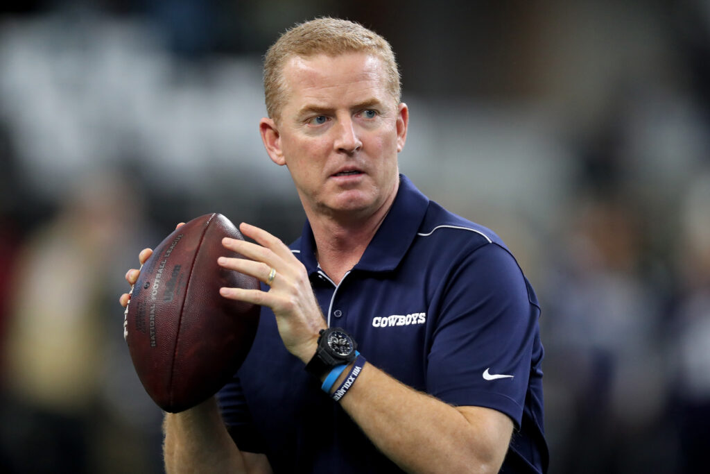 Head coach Jason Garrett of the Dallas Cowboys throws a football before the game against the Washington Redskins
