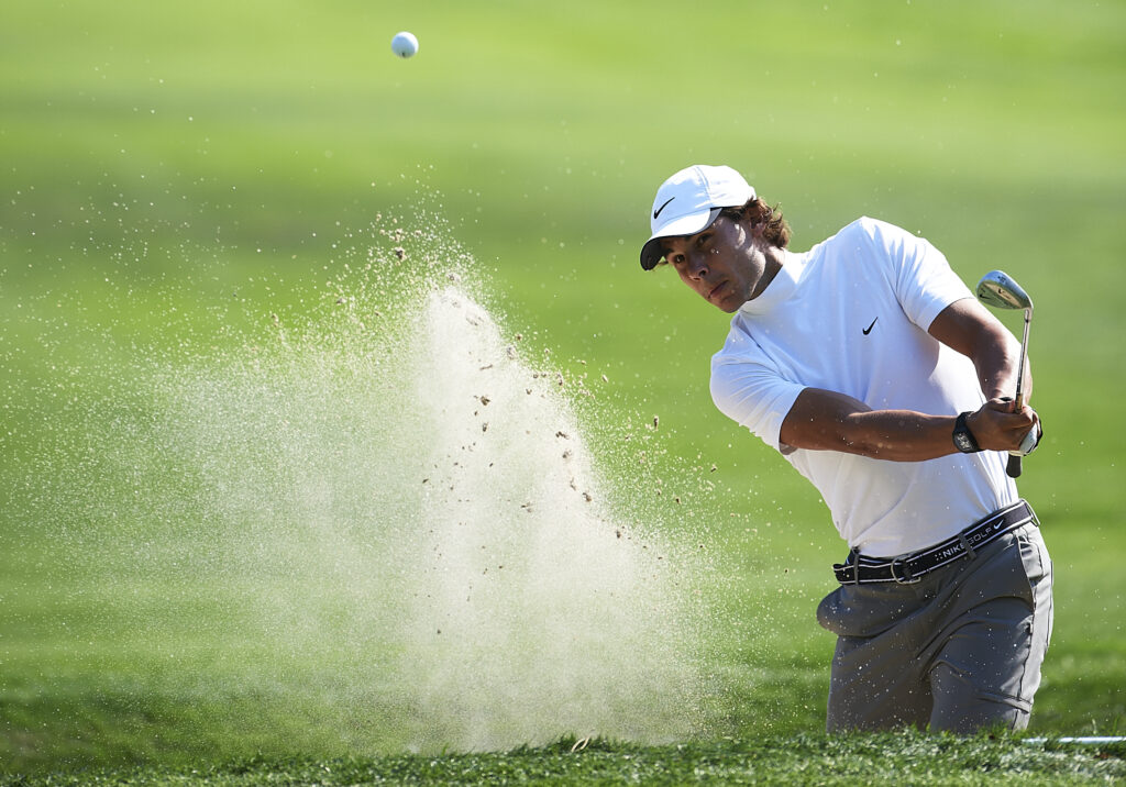 Rafael Nadal of Spain plays out of a bunker during the pro - am prior to the start of the Castello Masters Costa Azahar at the Club de Campo del Mediterraneo