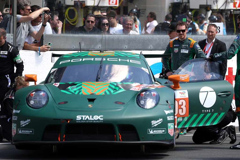 Michael Fassbender standing behind his Porsche GT3 car at the 22 24 Hours of Le Mans.