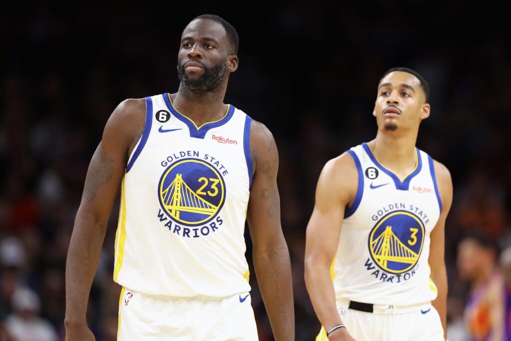 Draymond Green #23 and Jordan Poole #3 of the Golden State Warriors walk to the bench during the second half of the NBA game against the Phoenix Suns at Footprint Center.