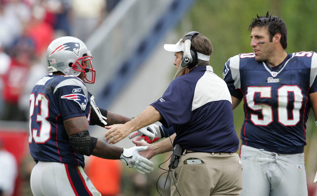 Patriots Kevin Faulk runs back to the sideline congratulated by head coach Bill Belichick and Mike Vrabel after coming up slowly from his big TD catch in the 3rd quarter as the New England Patriots beat the Buffalo Bills 19-17 on a safety in their season opener at Gillette Stadium.