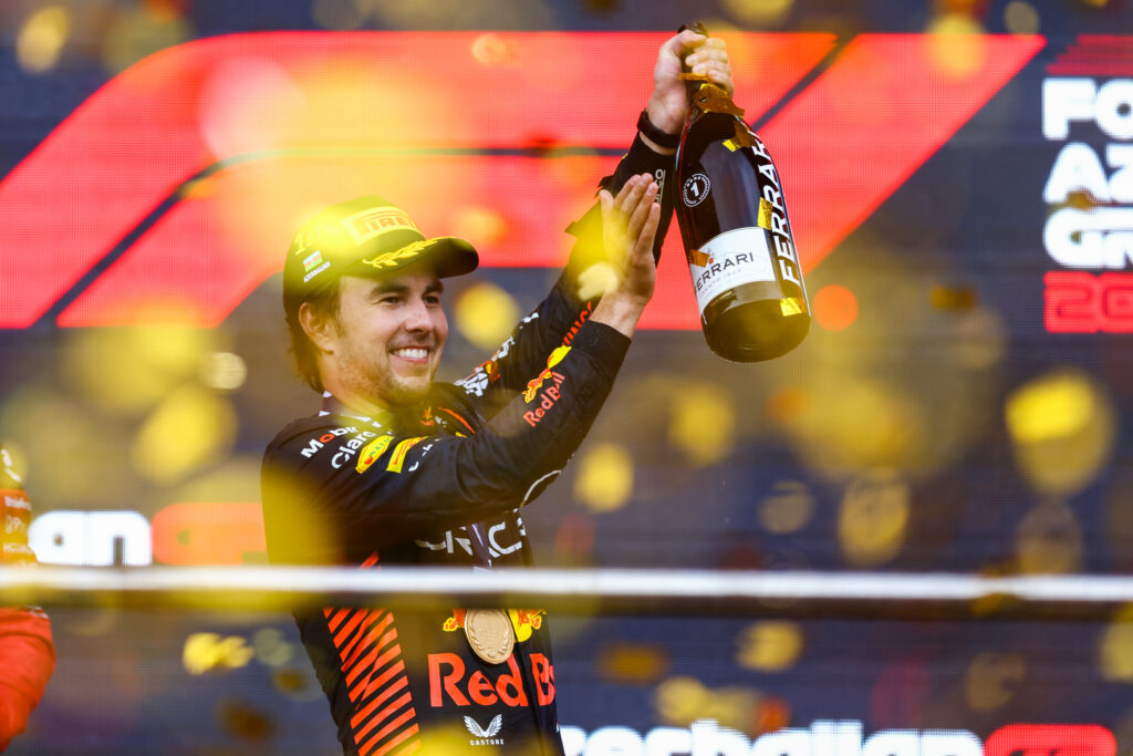 Sergio Perez of Red Bull holds up a bottle of champagne after winning the 2023 Azerbaijan Grand Prix