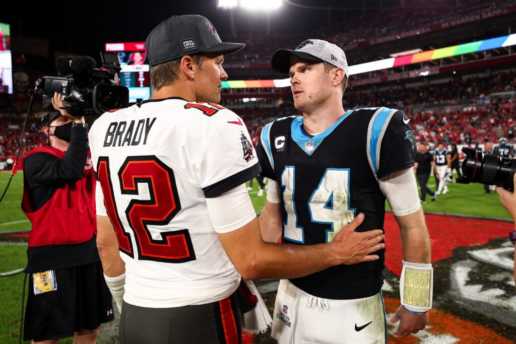 Tom Brady #12 of the Tampa Bay Buccaneers shakes hands with Sam Darnold #14 of the Carolina Panthers after an NFL game at Raymond James Stadium.