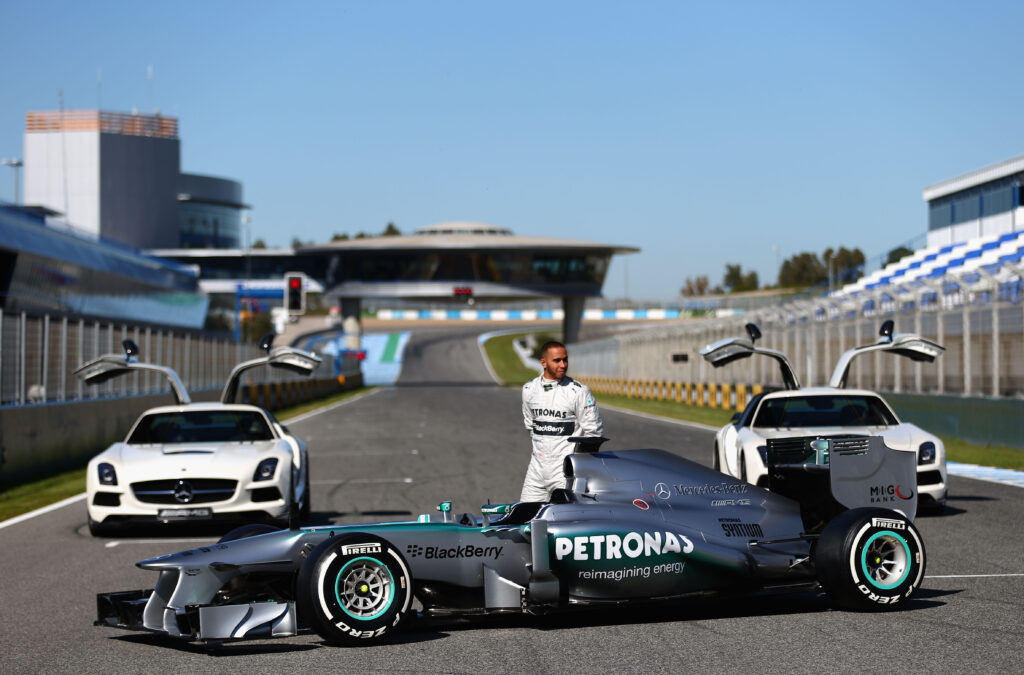 Lewis Hamilton standing beside his 2013 Mercedes F1 car at the team's launch event.