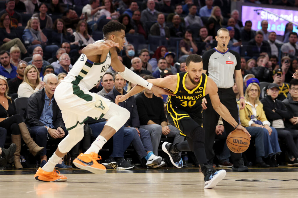 Stephen Curry #30 of the Golden State Warriors is guarded by Giannis Antetokounmpo #34 of the Milwaukee Bucks in the second half at Chase Center.