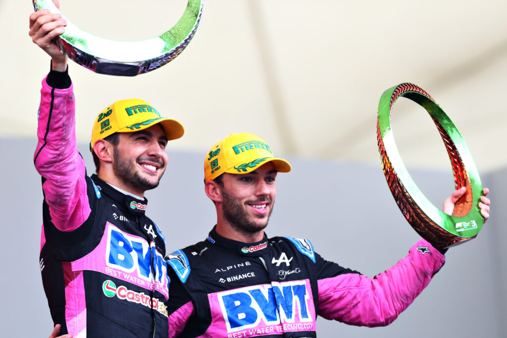 Esteban Ocon and Pierre Gasly of Alpine stand arm in arm as they hold up their trophies for the 2024 Brazilian Grand Prix
