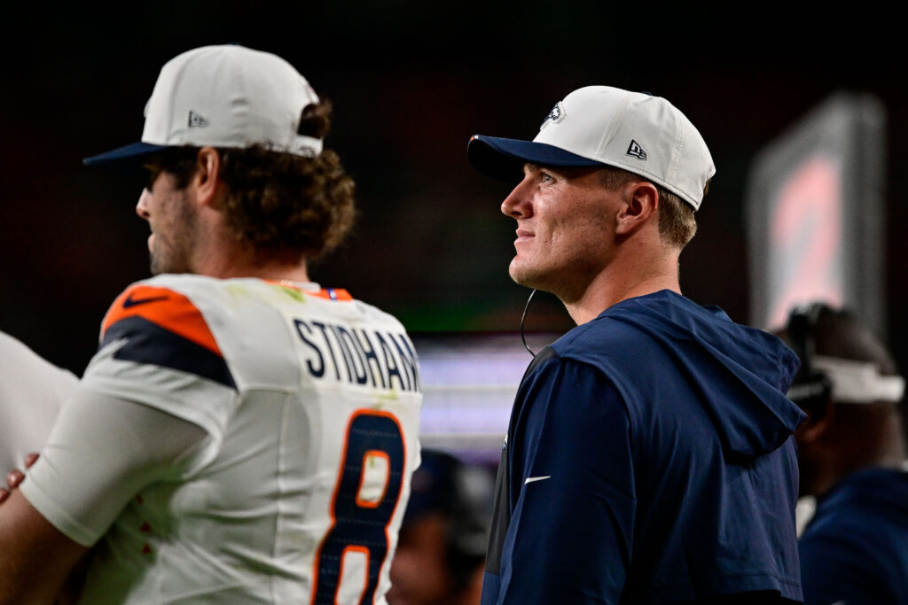 Denver Broncos quarterback Bo Nix (10) looks on next to quarterback Jarrett Stidham (8).