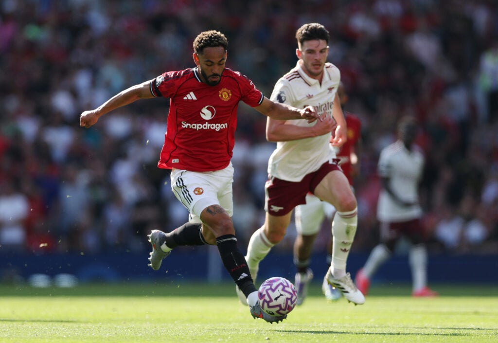 Matheus Cunha of Manchester United runs with the ball whilst under pressure from Declan Rice of Arsenal during the Premier League match between Manchester United and Arsenal at Old Trafford.