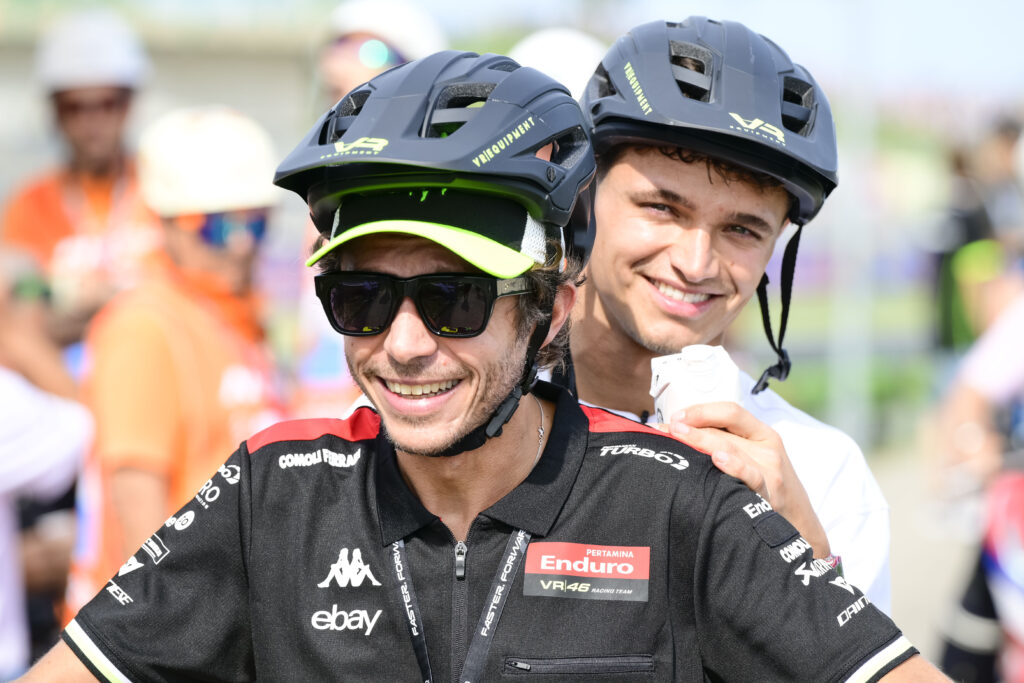 Lando Norris riding on the back of Valentino Rossi's bike at the MotoGP Of San Marino