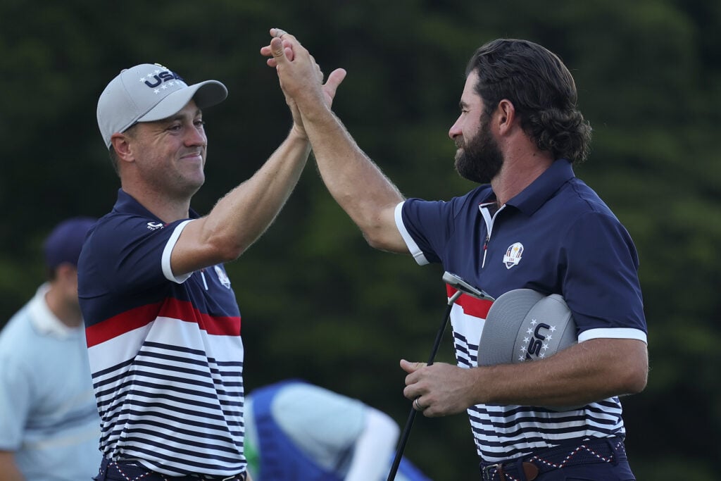 Justin Thomas of Team United States celebrates with teammate Cameron Young on the 13th hole green after defeating Ludvig Aberg of Team Europe and Rasmus Hojgaard of Team Europe, 6&5, during the Friday afternoon four-ball matches of the 2025 Ryder Cup
