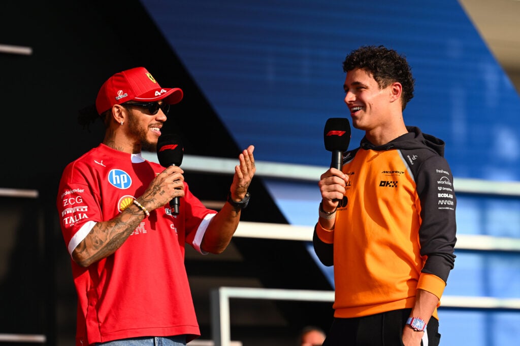 Lando Norris laughing with Lewis Hamilton during a fan event at the 2025 Qatar Grand Prix.