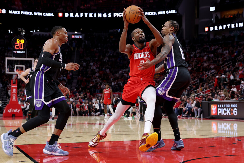 Kevin Durant #7 of the Houston Rockets steps to the basket between Demar Derozan #10 of the Sacramento Kings and Russell Westbrook