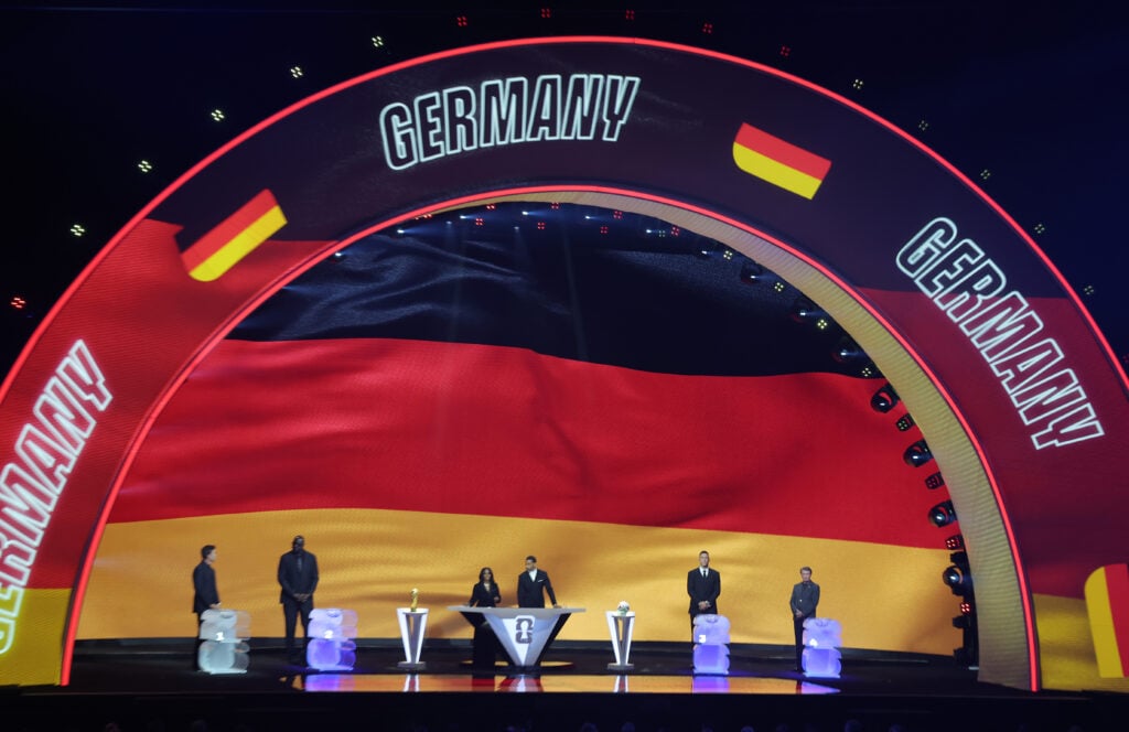 Draw assistant Tom Brady, Draw assistant Shaquille O’Neal, Co-Conductor Samantha Johnson, FIFA Legend Rio Ferdinand, Draw assistant Aaron Judge and Draw assistant Wayne Gretzky stand on stage as Germany is illuminated on the screen during the FIFA World Cup 2026.