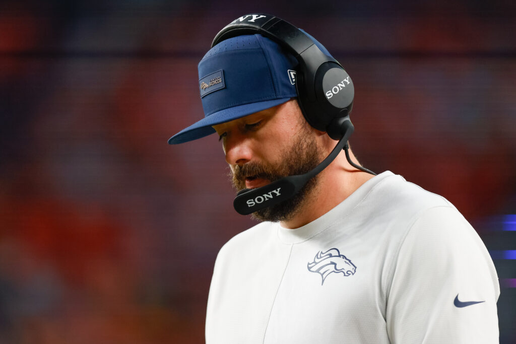 Offensive Pass Game Coordinator and Quarterbacks Coach Davis Webb of the Denver Broncos looks at a play sheet during the third quarter against the Green Bay Packers at Empower Field at Mile High.