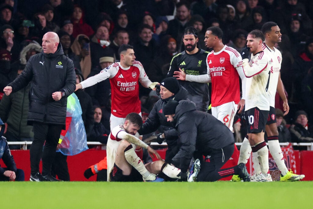 Conor Bradley of Liverpool is treated for injury as Gabriel Martinelli and Gabriel Magalhaes of Arsenal look on during the Premier League match between Arsenal and Liverpool at Emirates Stadium.