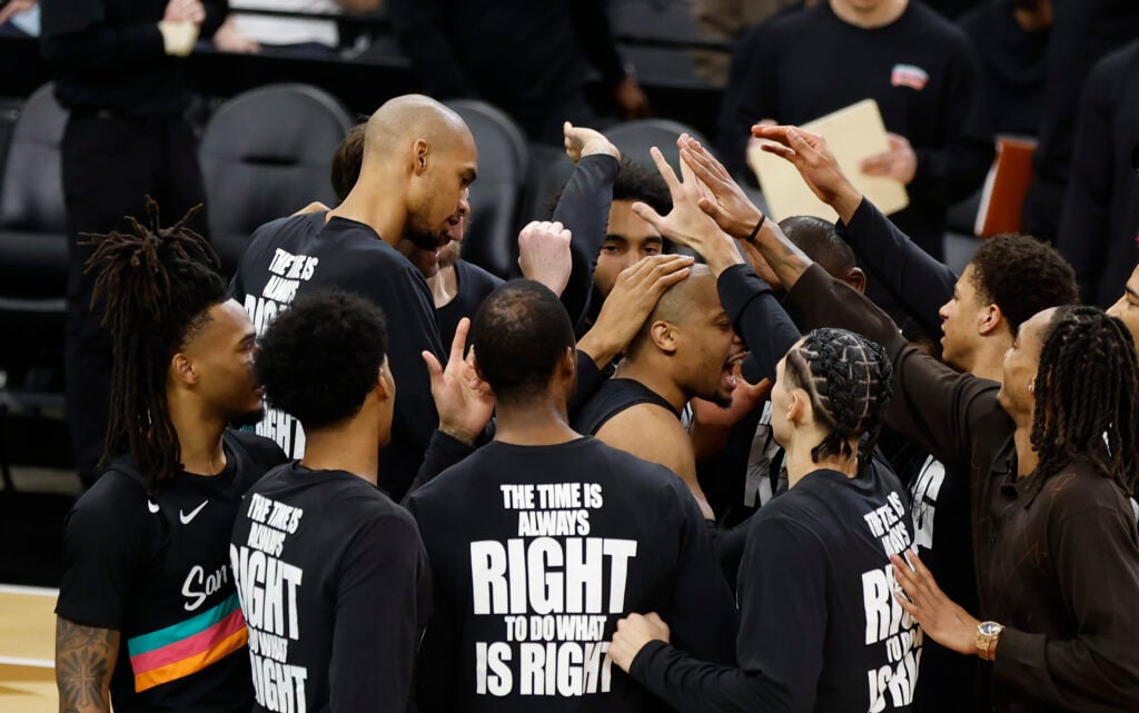 Victor Wembanyama #1 of the San Antonio Spurs puts his hand on Keldon Johnson during pre-game ritual before the start of their game against the Milwaukee Bucks at Frost Bank Center.