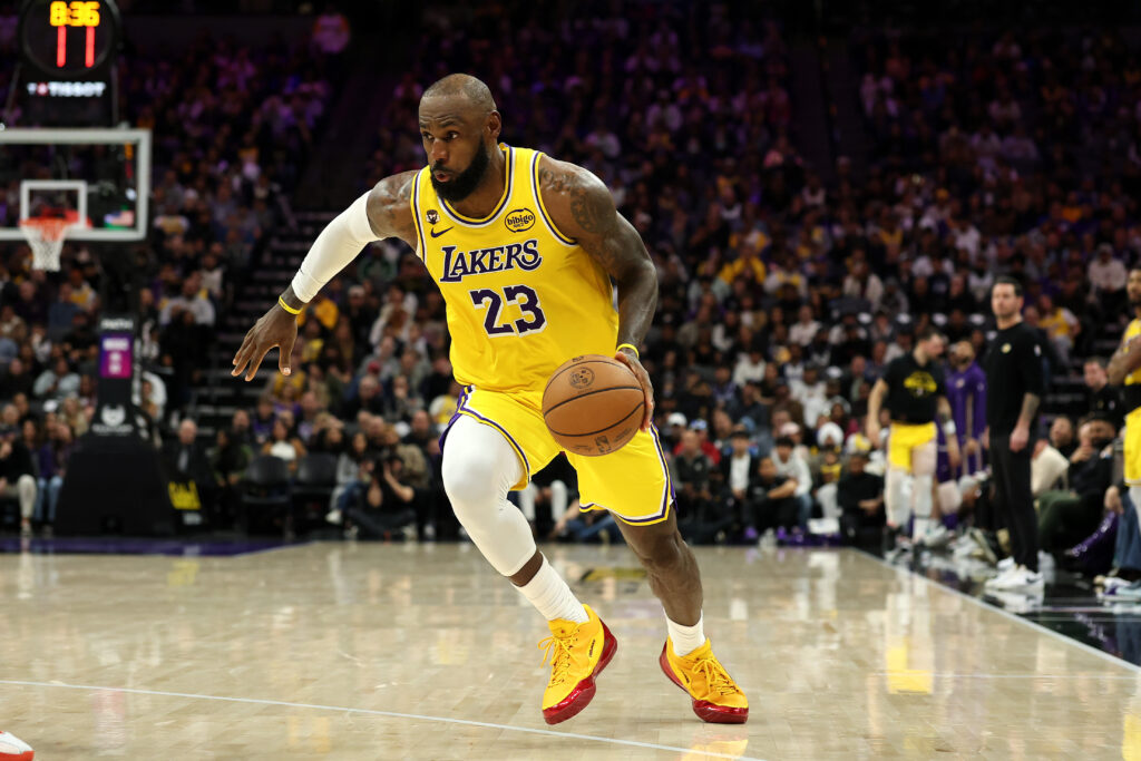 LeBron James #23 of the Los Angeles Lakers dribbles the ball during their game against the Sacramento Kings at Golden 1 Center on January 12, 2026 in Sacramento, California. James is wearing a patch to celebrate his record-setting 23rd NBA season.