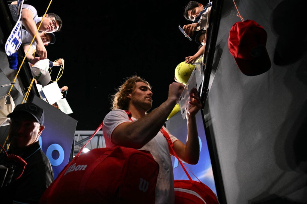 Stefanos Tsitsipas signs autographs after winning his first-round match at the 2026 Australian Open