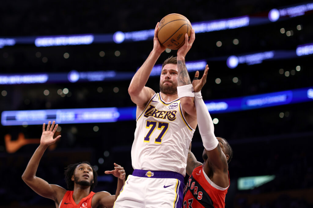 Luka Doncic #77 of the Los Angeles Lakers drives past Immanuel Quickley #5 and Jamal Shead #23 of the Toronto Raptors during the first quarter at Crypto.com Arena.