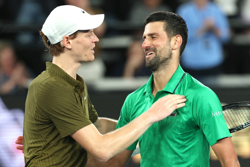 Serbia's Novak Djokovic (R) embraces Italy's Jannik Sinner after their men's singles semi-final match on day thirteen of the Australian Open tennis tournament in Melbourne.