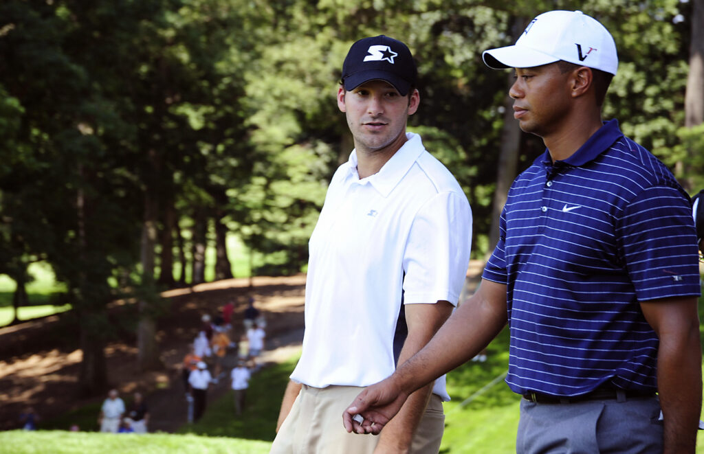 Tiger Woods of the US walks with Dallas Cowboys quarterback Tony Romo during a pro- am tournament on July 1, 2009