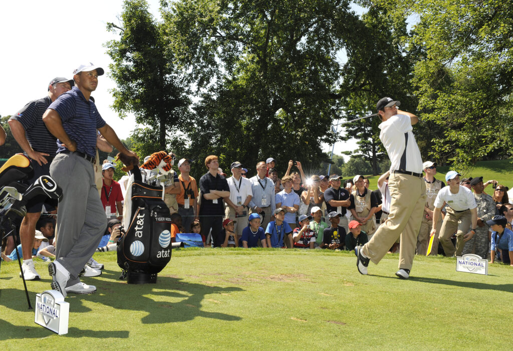 Tiger Woods, left, watches his playing partner Dallas Cowboys Q.B. Tony Romo hit from the seventh tee box during the Pro-Am round for the AT&T National at Congressional Country Club on July 1, 2009
