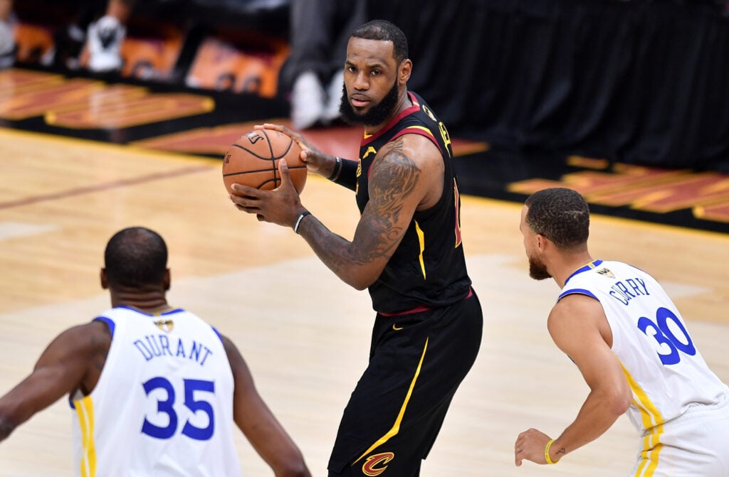 LeBron James #23 of the Cleveland Cavaliers is defended by Stephen Curry #30 and Kevin Durant #35 of the Golden State Warriors in the first quarter during Game Three of the 2018 NBA Finals.