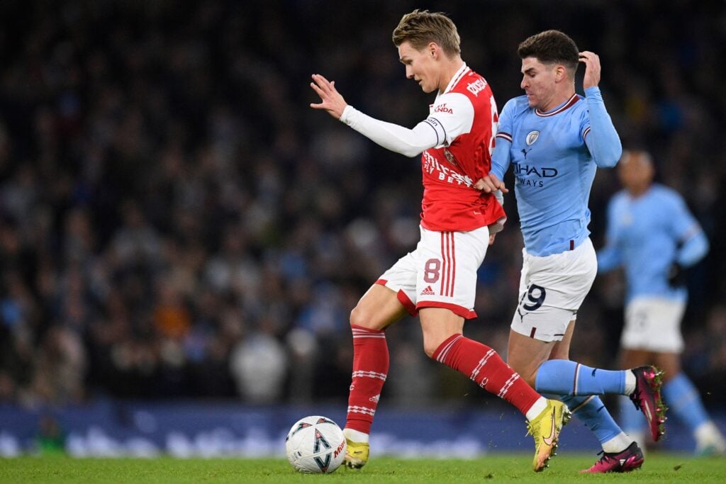 Arsenal's Norwegian midfielder Martin Odegaard challenges Manchester City's Argentinian striker Julian Alvarez (R) the English FA Cup.