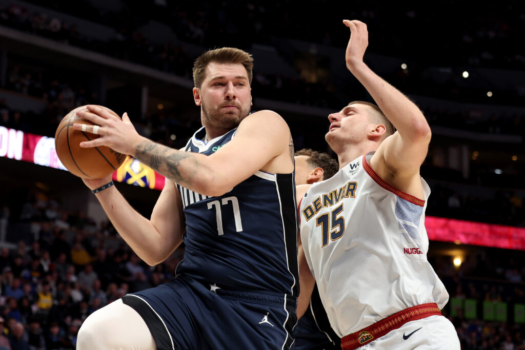 Luka Doncic #77 of the Dallas Mavericks grabs a rebound against Nikola Jokic #15 of the Denver Nuggets at Ball Arena on February 15, 2023.