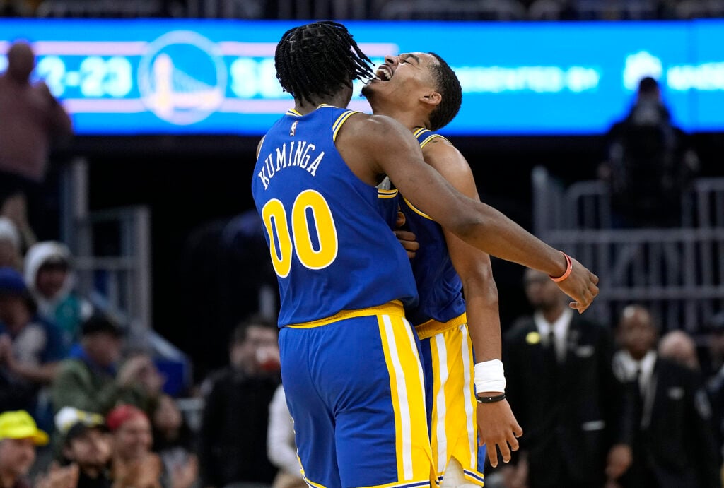 Jonathan Kuminga #00 and Jordan Poole #3 of the Golden State Warriors celebrate after Kuminga scored against the Charlotte Hornets during the fourth quarter at Chase Center on December 27, 2022.
